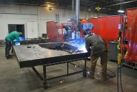 Different angle of the shop employee welding metal